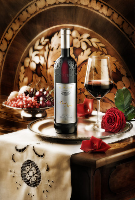 Foto still life del vino Pinot Nero con bicchiere, vassoio,alzatina con frutta su tavolo antico