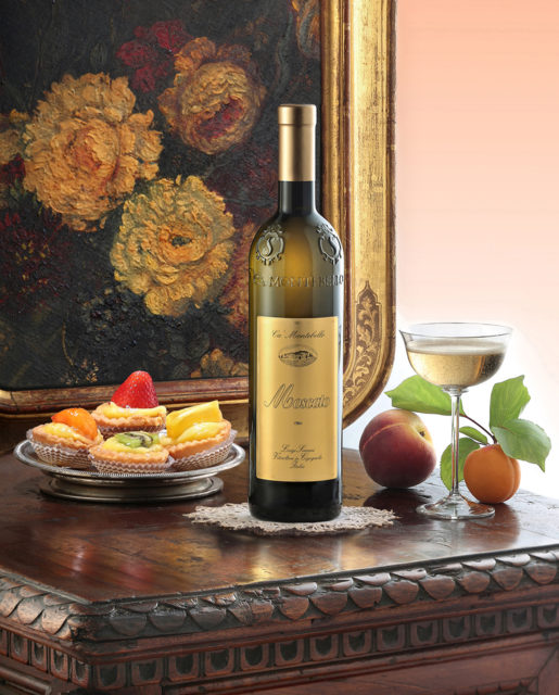 Foto still life del vino Moscato Scarani con dipinto bicchiere e frutta