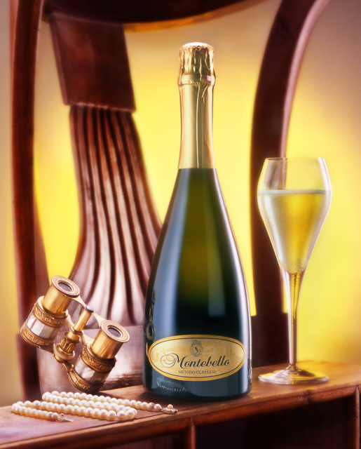 Foto still life del vino Pinot Spumante Montebello con bicchiere,binocolo da teatro, collana di perle e sedia del '700 di sfondo